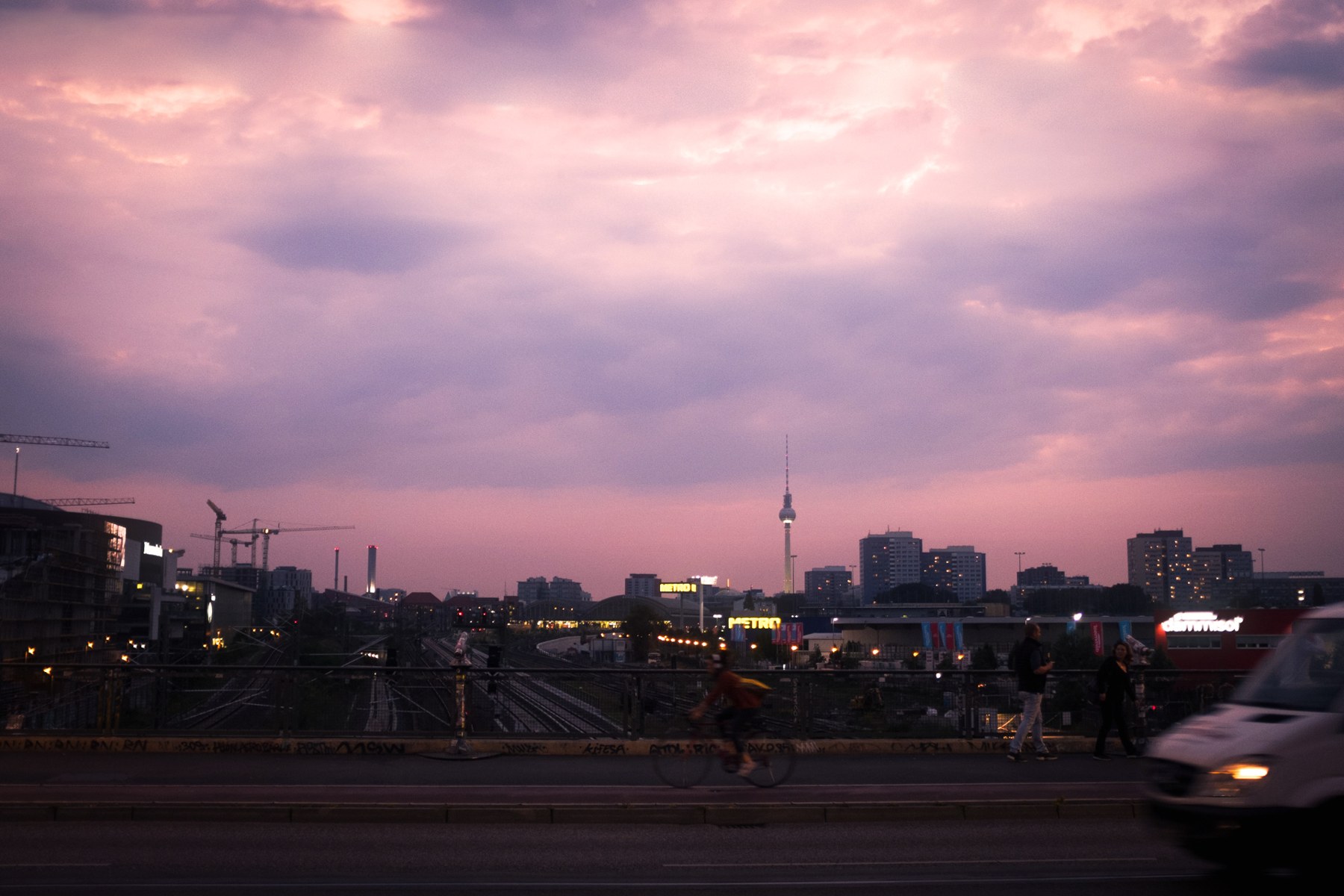 Berlin skyline under a luminous peach and lilac sunset, with overhead wires removed