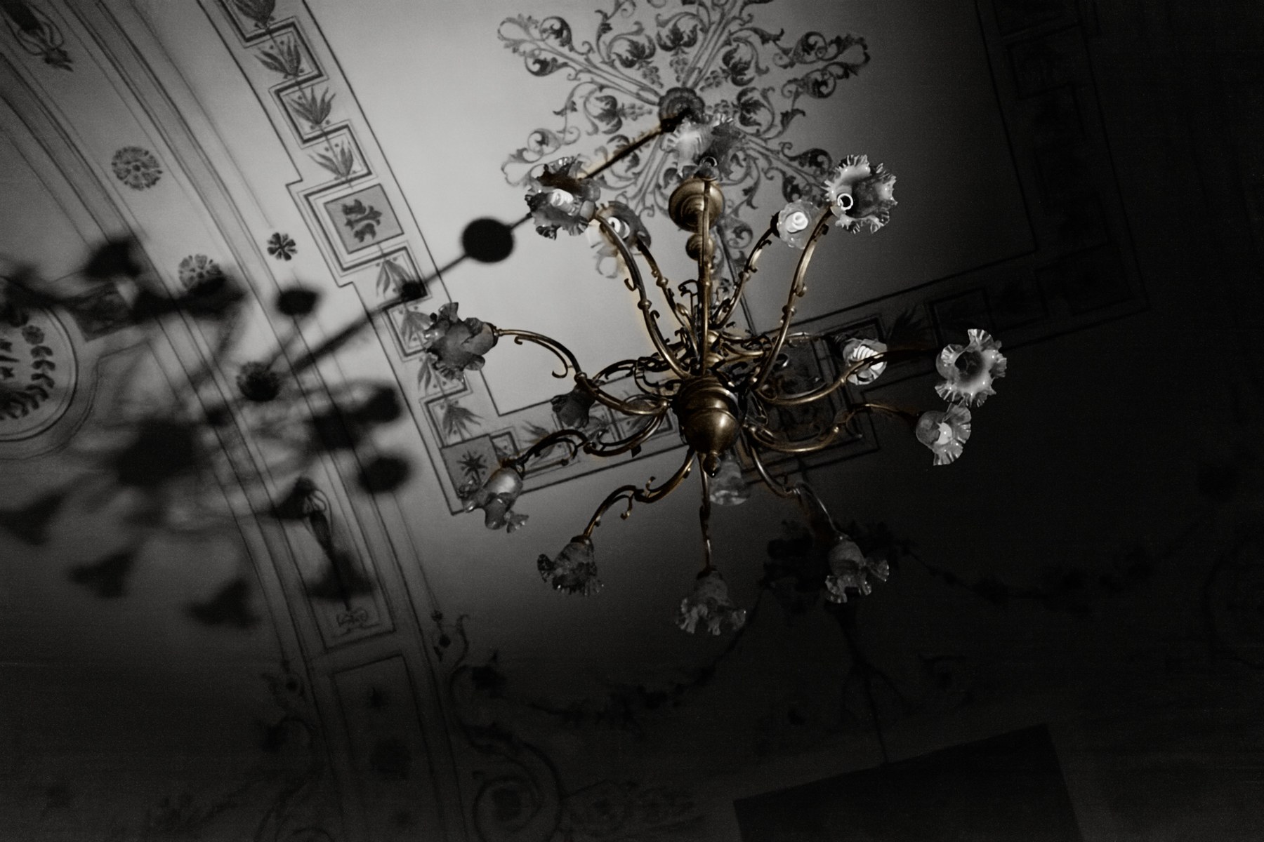 A restored chandelier with warm brass and a neutral ceiling